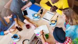 Group meeting around table with coffee and laptops